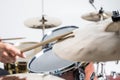 Close up of hands of male drummer holdning drumsticks sitting and playing drums on white background Royalty Free Stock Photo