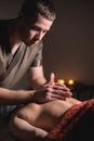 Close-up of the hands of a male masseur doing back massage to a girl at the spa. Low key high contrast shallow depth of Royalty Free Stock Photo