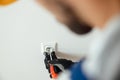 Close up of hands of male worker, professional electrician in protective gloves using screwdriver while installing new Royalty Free Stock Photo