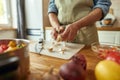 Close up of hands of man in apron peeling garlic while preparing healthy meal, soup in the kitchen. Cooking at home Royalty Free Stock Photo