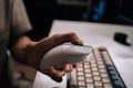 Close-up hands of man cleaning computer mouse and keyboard with disposable wipe, emphasizing hygiene and sanitation for Royalty Free Stock Photo