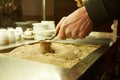 Close up hands of a man cooking turkish coffee on hot golden sand. Royalty Free Stock Photo