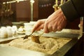 Close up hands of a man cooking turkish coffee on hot golden sand. Royalty Free Stock Photo
