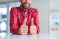 Close up of hands man doing thumbs up gesture over white table