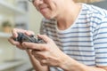 Close up hands of man, gamer using gaming controller or game pad when play video console game or online computer game at home. Royalty Free Stock Photo