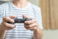 Close up hands of man, gamer using gaming controller or game pad when play video console game or online computer game at home. Royalty Free Stock Photo