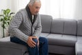 close up hands man with his knee joint pain in sofa, pain in the elderly, health care. Grandfather with knee pain Royalty Free Stock Photo