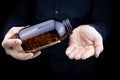 A close-up of the hands of a man holding a jar of fish oil capsules pours capsules on his palm Royalty Free Stock Photo