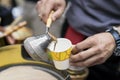 Close-up of hands of man making traditional turkish coffee in copper turk on hot sand and pours freshly prepared into Royalty Free Stock Photo