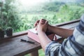 Close up hands of man reading and praying with a holy bible in morning on wooden table. christian concept