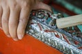 Close up hands man using a brass brush for polishing an old red and golden altar table cracked before repair Royalty Free Stock Photo