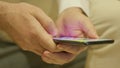 Close up on hands of a man using phone indors