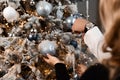Close-up of the hands of a man and a woman decorating a christmas tree with balls Royalty Free Stock Photo