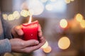 Close-up of hands of mature man indoors at home at Christmas, holding candle. Royalty Free Stock Photo