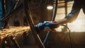 Close Up of Hands of a Metal Fabricator Wearing Safety Gloves and Grinding a Steel Tube Sculpture