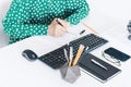 Close-up of hands middle-aged woman in green blouse typing on keyboard laptop computer, concrete holder with pencils and pens, Royalty Free Stock Photo