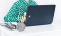 Close-up of hands middle-aged woman in green blouse typing on keyboard laptop, concrete holder with pencils and pens, notebook, Royalty Free Stock Photo