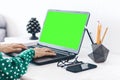 Close-up of hands middle-aged woman typing on keyboard green screen laptop, concrete holder with pencils and pens, notebook, Royalty Free Stock Photo