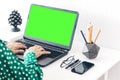 Close-up of hands middle-aged woman typing on keyboard green screen laptop, concrete holder with pencils and pens, notebook, Royalty Free Stock Photo