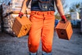 Close up on hands and midsection of unknown man construction worker taking orange hollow clay blocks ar warehouse or construction Royalty Free Stock Photo