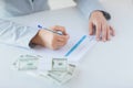 Close up of hands with money filling tax form Royalty Free Stock Photo