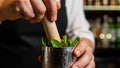 Bartender muddling fresh mint leaves in. Royalty Free Stock Photo