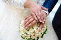 Close-up of the hands of the newlyweds with wedding rings, gently touch the wedding bouquet of peonies. Royalty Free Stock Photo