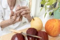 Close up of hands,old elderly cut her finger with a knife while slicing fruit in kitchen,senior woman pinching her index finger, Royalty Free Stock Photo