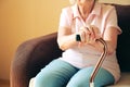 Old woman sitting with his hands on a walking stick. Senior people health care. Royalty Free Stock Photo