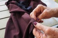 Close-up of hands old woman sewing cloth while sitting in balcony Royalty Free Stock Photo