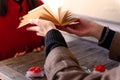 Close-up of hands with an open book. Magical atmosphere. Two lovers. Two small gifts with a red bow