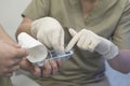 Close-up of the hands of an ophthalmologist surgeon with the help of the hands of an assistant surgeon takes a sterile instrument