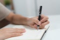 Close up hands of person writing note to notebook pages Royalty Free Stock Photo