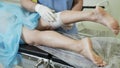 Close-up hands of phlebologist in gloves put bandage on his leg after sclerotherapy procedure