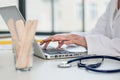 Close-up of the hands of a physician typing on laptop in the off