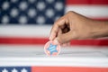 Close up of Hands placing I voted Early sticker inside the ballot box - Concept of Early voting in us election.