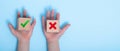 close-up of a hands placing two wooden blocks on a blue background. True and false symbols accept rejected for evaluation, Yes or