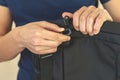 close-up. Hands with a plastic carabiner.The guy fastens the belt to the bag. Man holds belt fastener in hand
