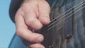 Close-up of hands playing bass guitar. Stock. Male hands of guitarist playing chords on bass guitar. Music performed on Royalty Free Stock Photo