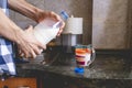 Close up hands pour water in the glass on kitchen table toned Royalty Free Stock Photo