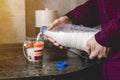 Close up hands pour water in the glass on kitchen table toned Royalty Free Stock Photo