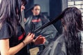 Close up hands of professional hairdresser combing hair of young Royalty Free Stock Photo