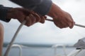 Close up of hands pulling a rope, sheet on a sailboat Royalty Free Stock Photo