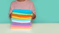 Close-up of hands putting stack of fresh bath towels. multi-colored rolls of towels in a wicker basket on a blue Royalty Free Stock Photo