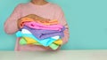 Close-up of hands putting stack of fresh bath towels. multi-colored rolls of towels in a wicker basket on a blue Royalty Free Stock Photo
