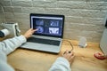 Close-up of hands of radiologist doctor dentist analyzing panoramic x-ray on laptop screen monitor in dentist office. Dental