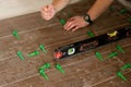 Close up hands of repairman laying tiles with tile leveling system on the floor in a new house