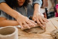 Close up of hands rolling clay with a wooden rolling pin at workshop Royalty Free Stock Photo