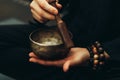Close-up of hands with rosary playing on singing bowls. Relaxation and meditation. Alternative medicine.