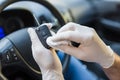 Close up of hands in rubber gloves disinfecting car key with wet wipe in vehicle interior Royalty Free Stock Photo